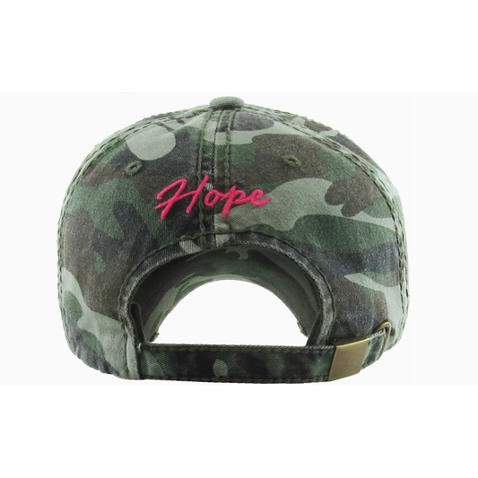 Camouflage cap with 'Hope' embroidered in pink on a white background