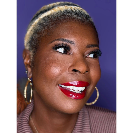 Woman with styled hair and red lipstick against a purple background wearing c-curl lash Sapphire