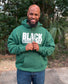 Male wearing a forest green hoodie with “Black Excellence” in bold white puff print.