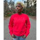 Woman modeling a red sweatshirt featuring the "Black excellence" design in puff print.
