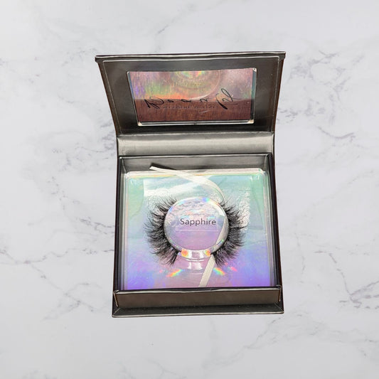 Eyelash packaging with 'Sapphire' label on a marble surface