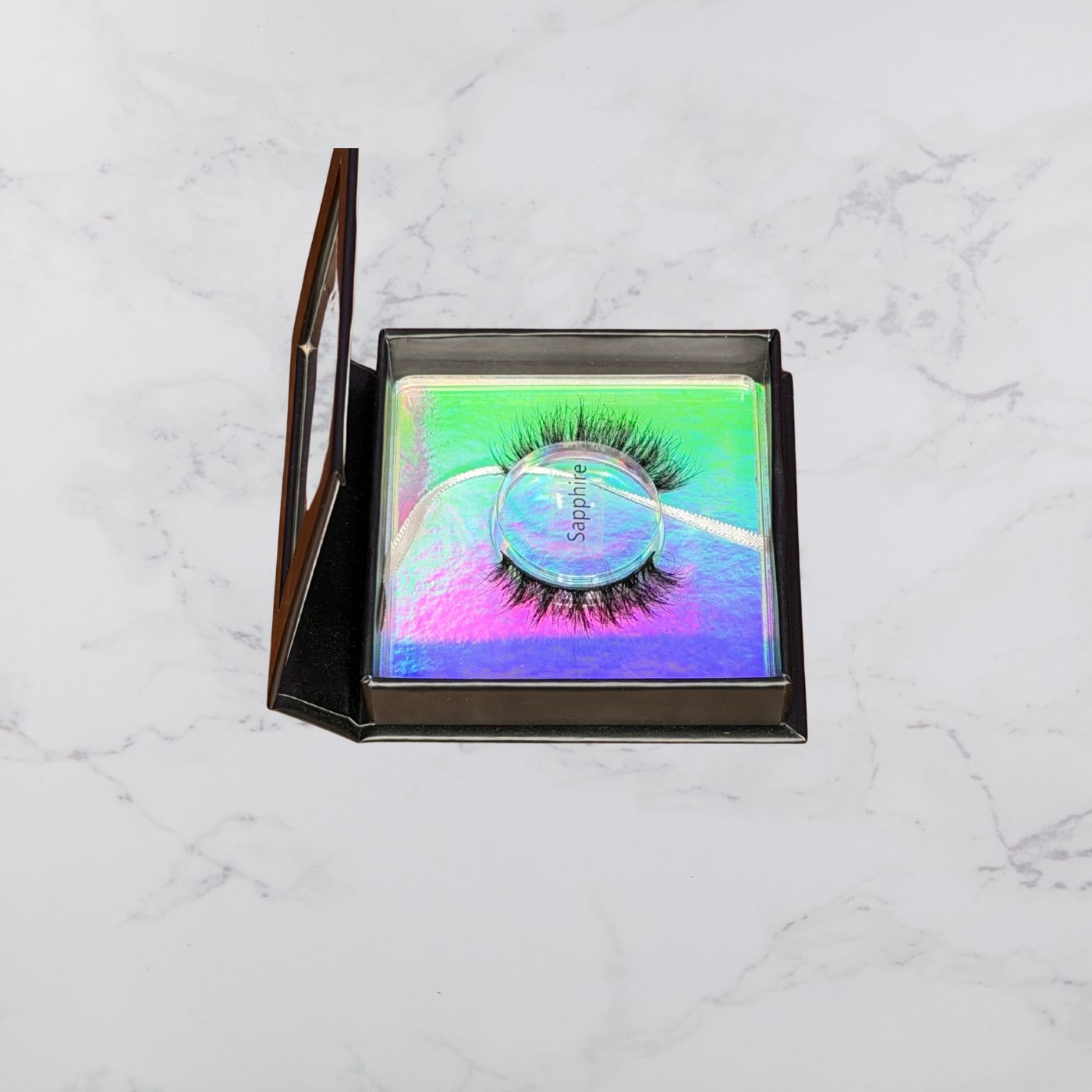 Eyelashes in a colorful case on a marble surface