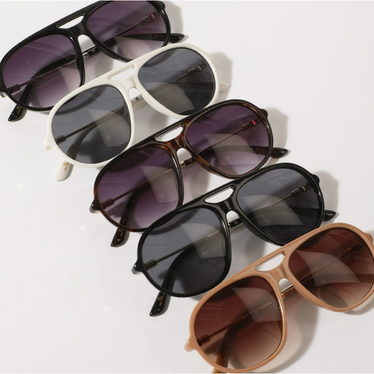 Five pairs of sunglasses with different frame colors and lens shades on a white background.